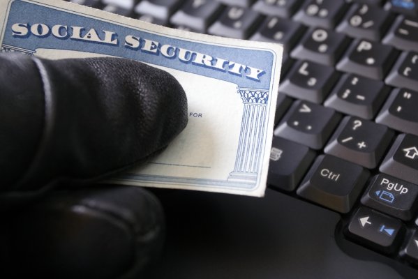 zander id theft protection service overview features hand with black glove holding social security card black computer keyboard in the background